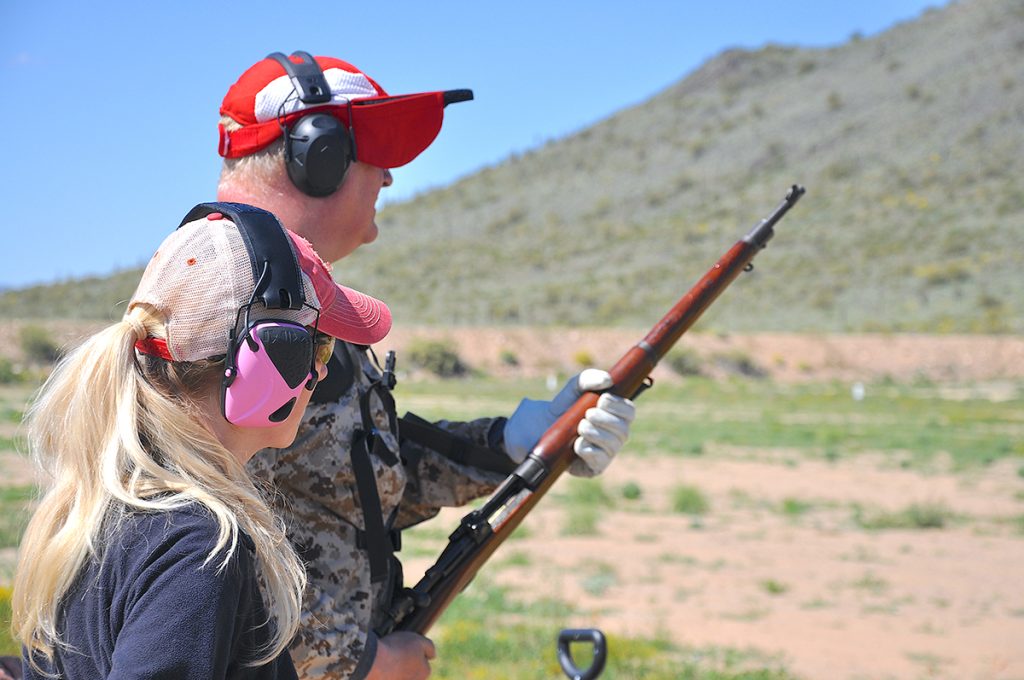 Competitors on the firing line firing a vintage rifle.