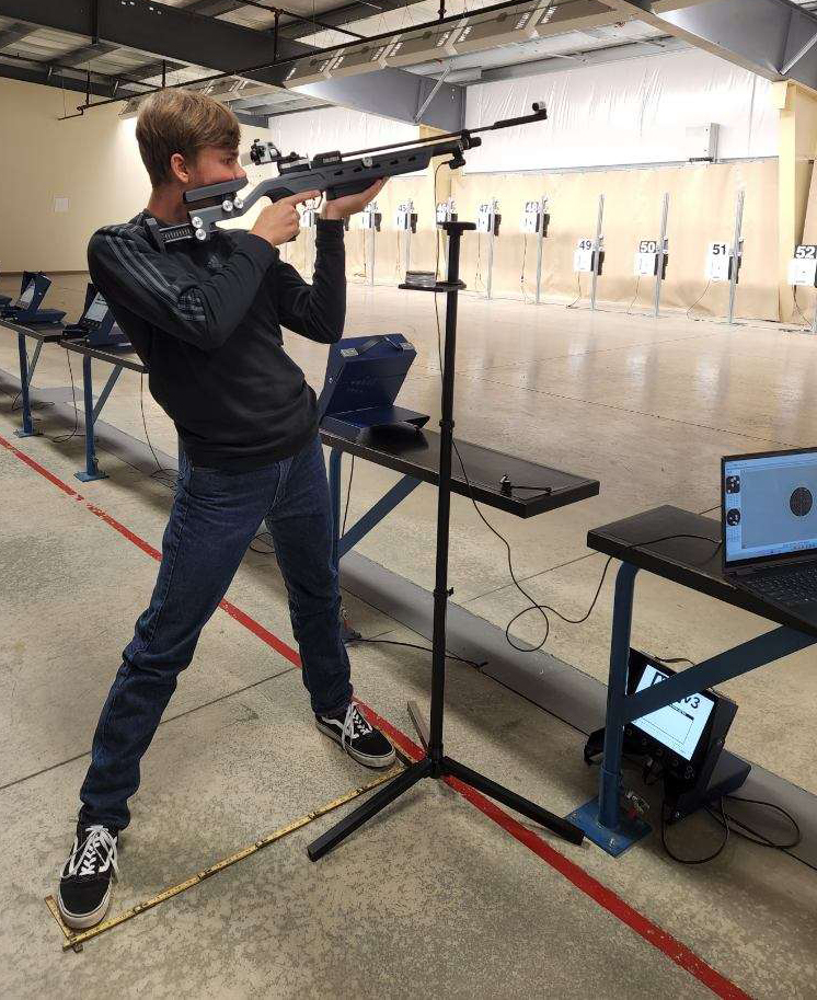 Junior firing a sporter air rifle at the range.