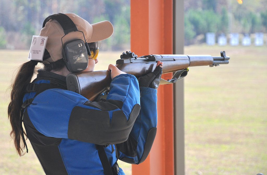 Rifle competitor taking aim in the standing position on the range.