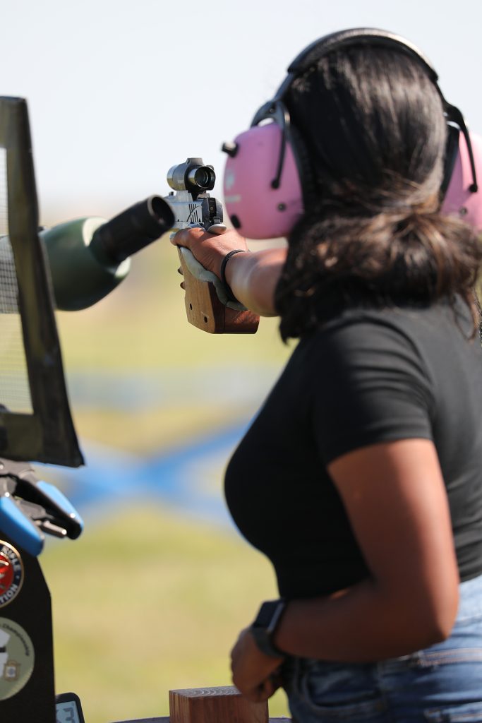 Tanya aiming her pistol downrange at targets.