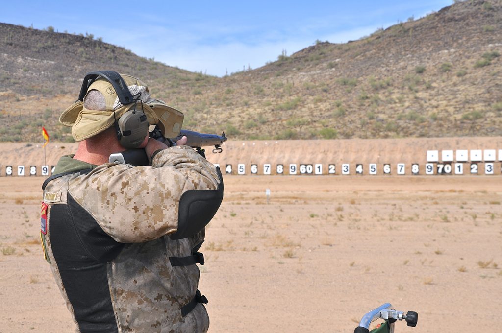 A competitor aiming a rifle at targets downrange.