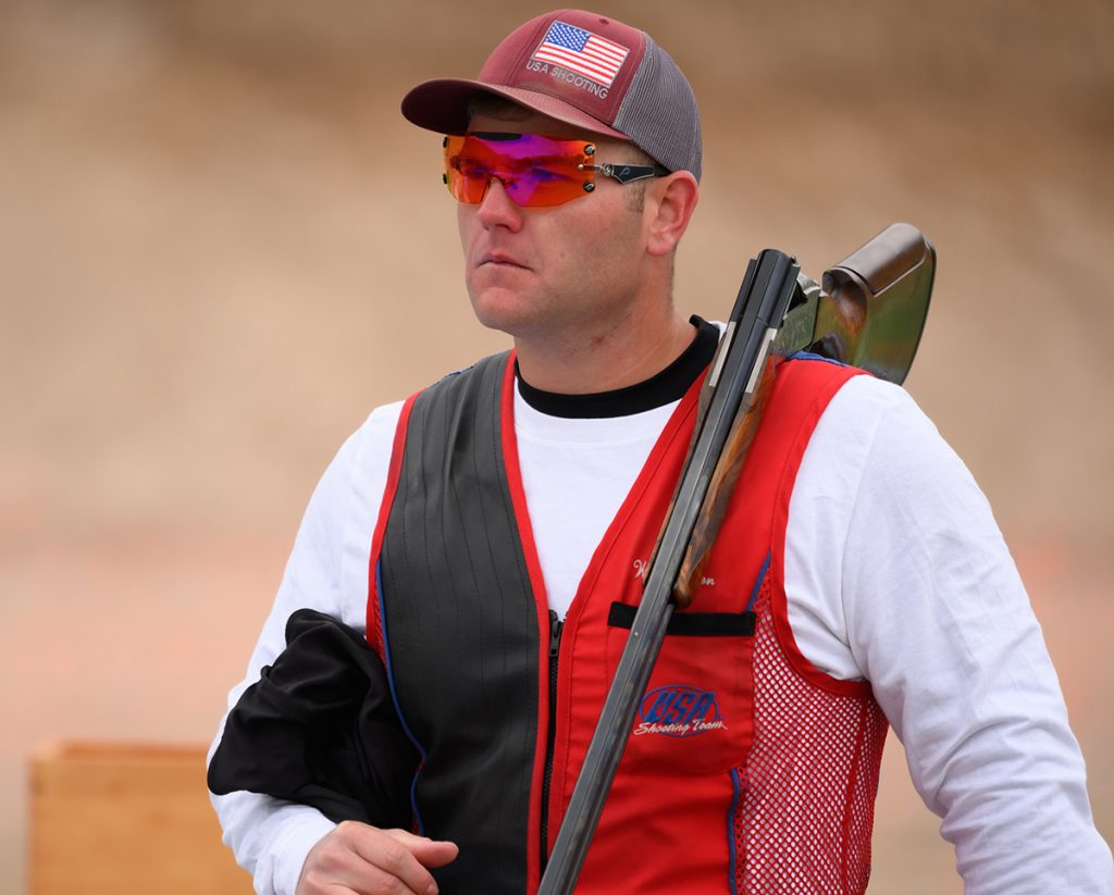 William Hinton at a competition with his shotgun over his shoulder.