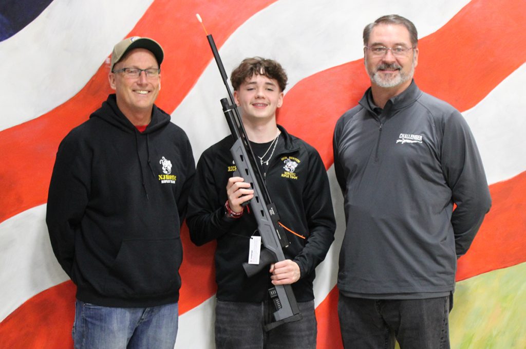 Brayden Rich with rifle and coaches.