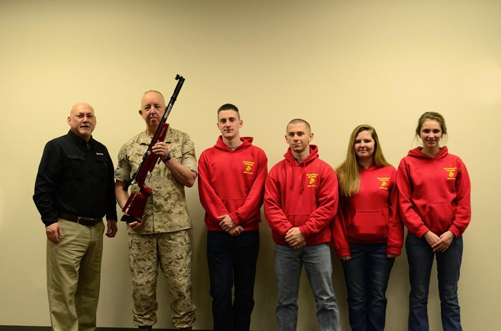 Mark DeBoard, Shooting Service Manager at Crosman Corporation, presents the winning sporter team, R-S Central HS MCJROTC from Rutherfordton, NC, with a new red Crosman air rifle. Team members are Baylee Boone, Spencer White, Jesse Bradley and Taylor Wease and Coach Major Russell Armentrout.
