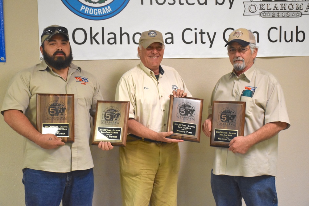 CMP’s Cris Stone presents awards to Daniel Miller, left, winner of the EIC .22 Rimfire Pistol Match and his partner in the Pistol Team Match, Peter Adams, right. The pair, firing under the team name “Moonshine Monkeys” placed first with a score of 524-6x. 