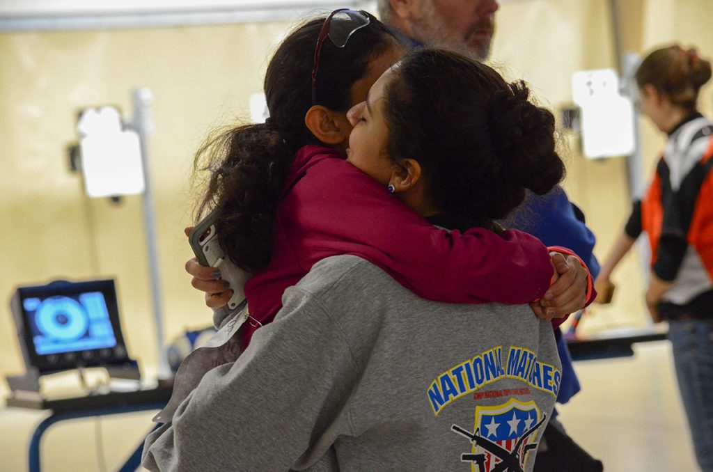 After Emma completed firing, she ran to her sister and gave her a heart-warming hug.