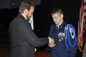 James Hall was the recipient of Badge #2 back in 2001. He now is an employee of the CMP and can be seen at events pinning talented juniors with Junior Distinguished Badges of their own. He also now competes in air pistol events.