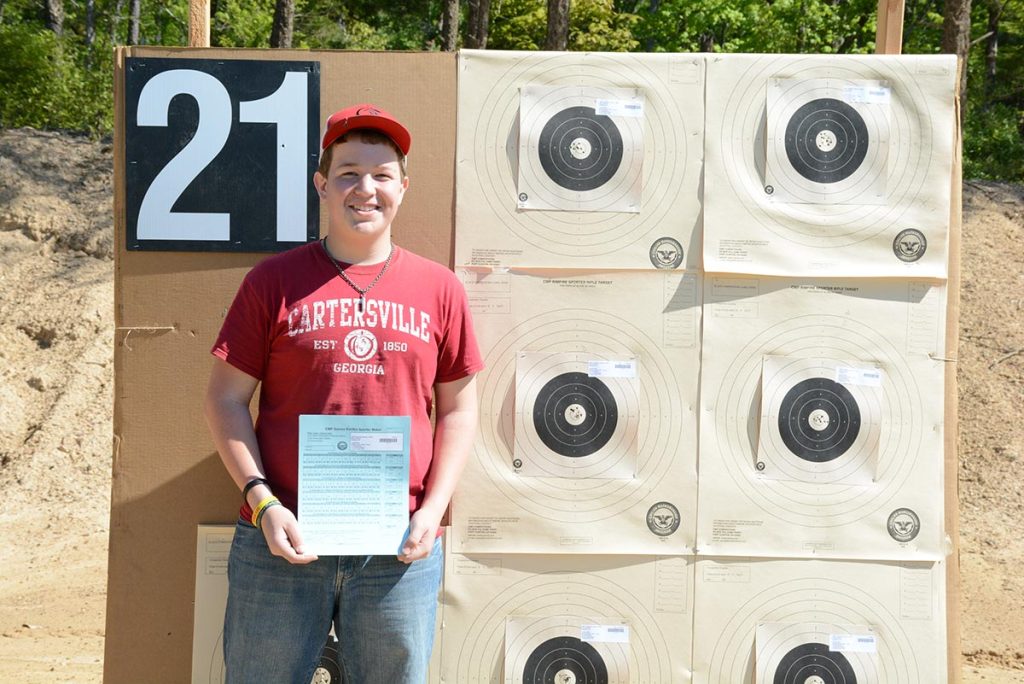 Sam stands in front of his flawless Rimfire targets.
