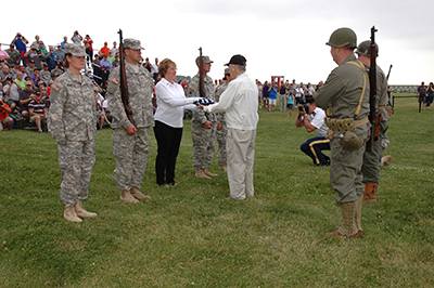 Veteran Jack Price handed off the colors to Susie Charlton, whose father served at the Battle of Saipan.